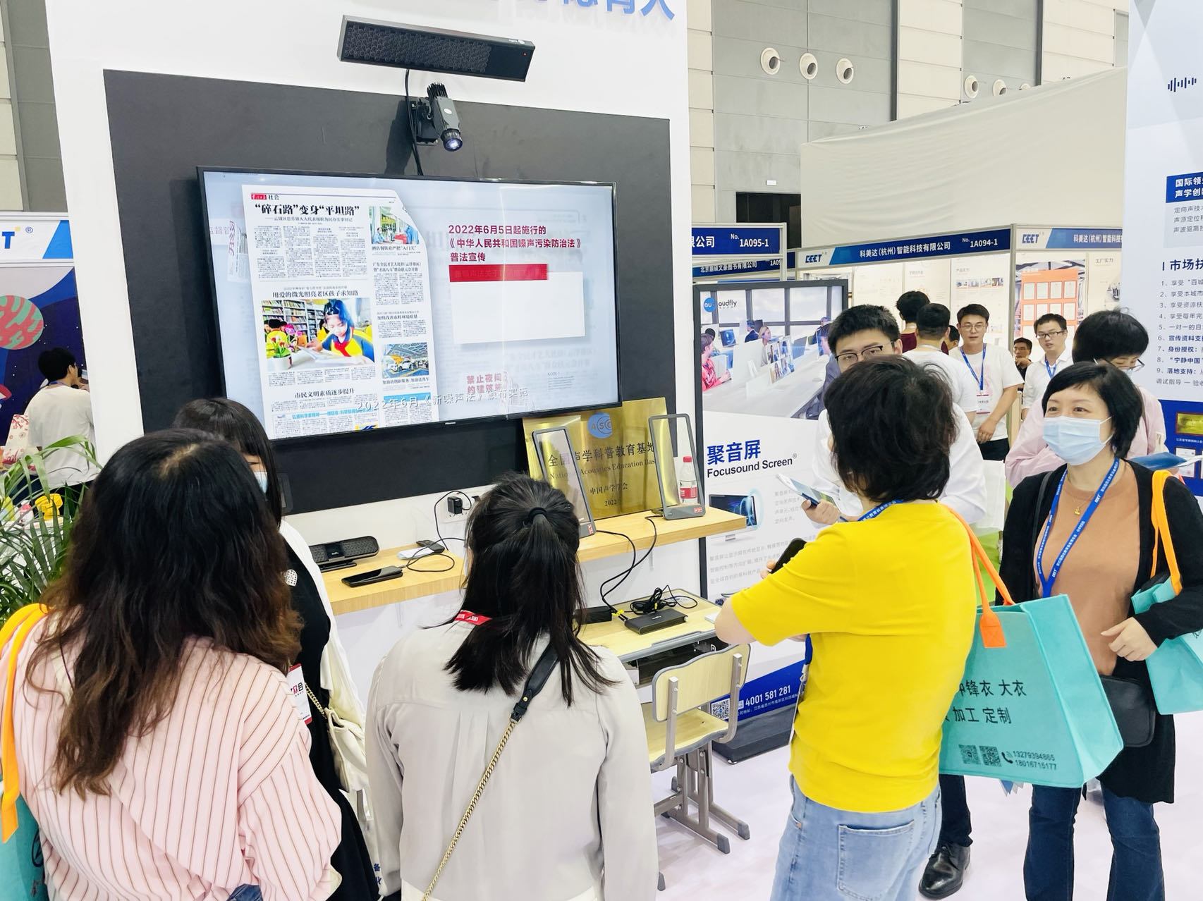 工作人員讓參展者沉浸式體驗屏幕定向音響聚音屏這款黑科技產品